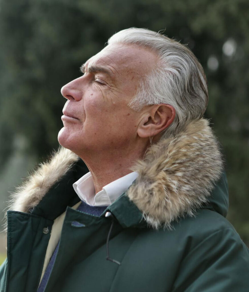 Portrait of Ahsan Majeed, founder of BrainStak, in a green winter coat with fur-lined hood, gazing confidently into the distance.